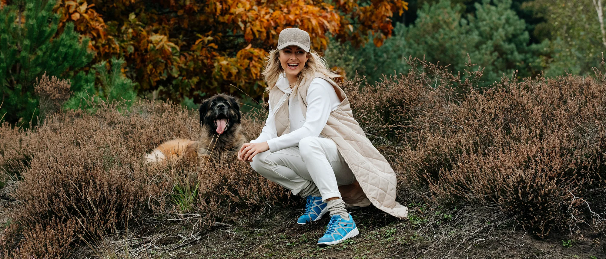 Vrouw draagt sneakers tijdens wandeling in de natuur met haar hond